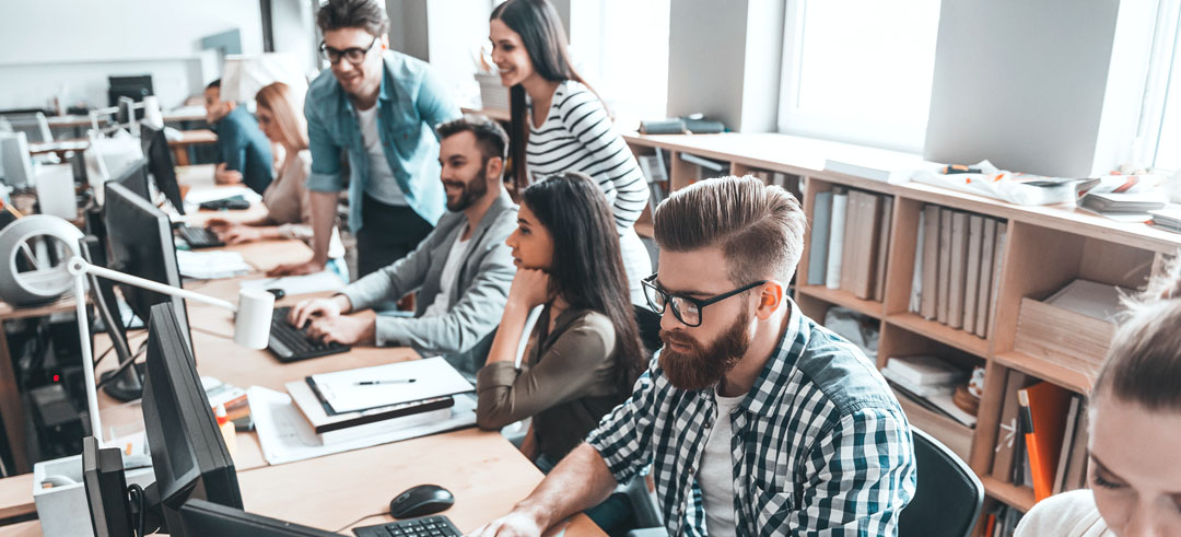 Diferentes trabajadores con ordenadores en una oficina 