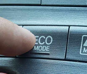 Persona apretando el botón de modo eco en un vehículo